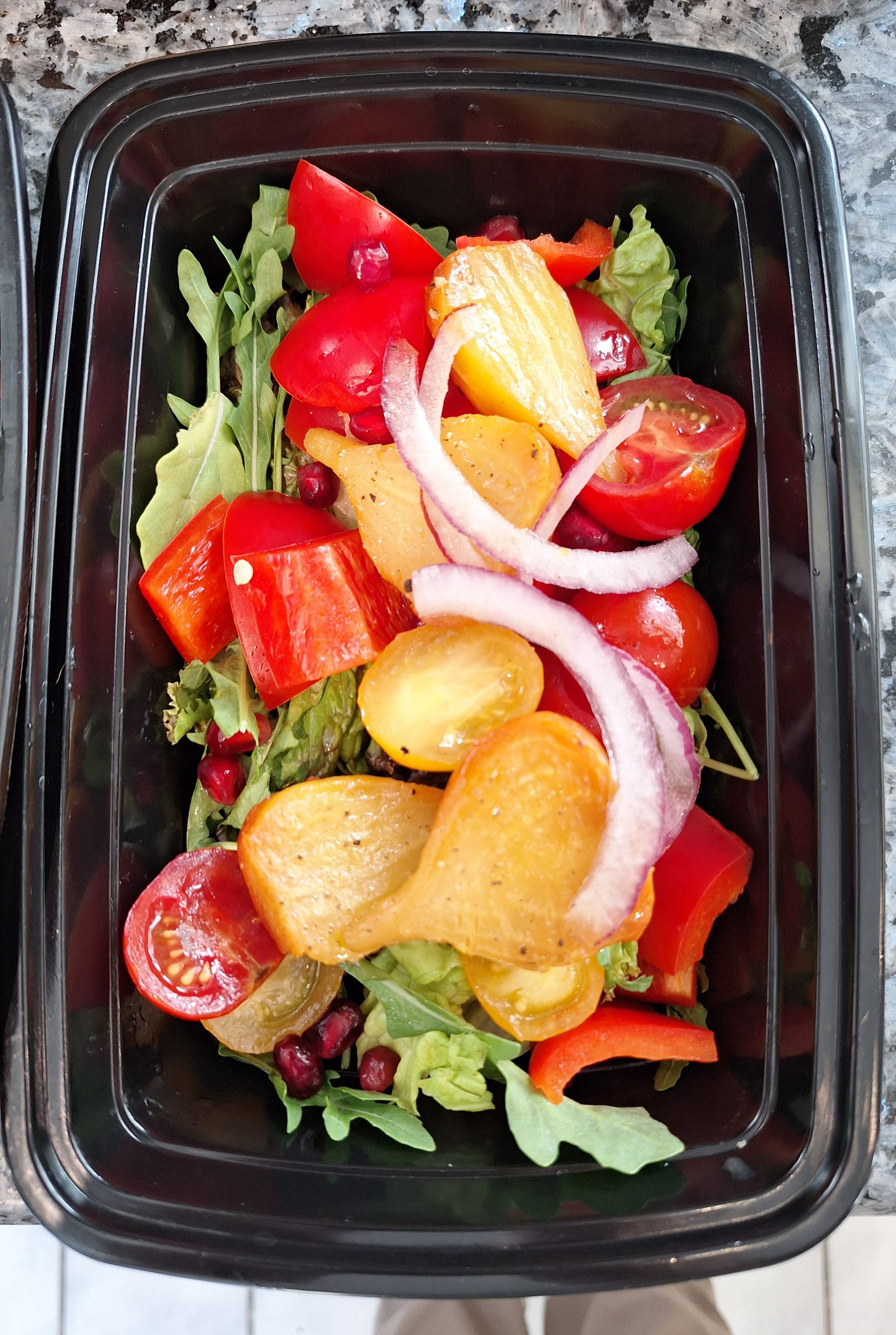 Two containers of food are sitting on a wooden table.