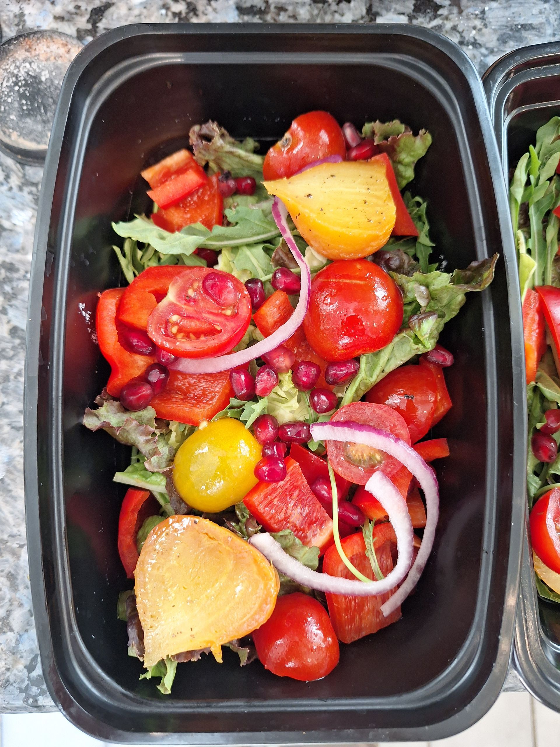 Plate with tuna carpaccio, fried scallops, avocado, wine bottle and glass, and cutlery on a marble surface.