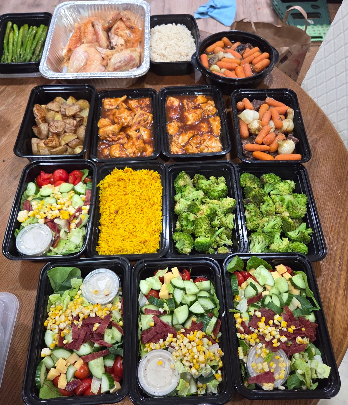 Prepared meal containers: chicken, rice, vegetables, salads.