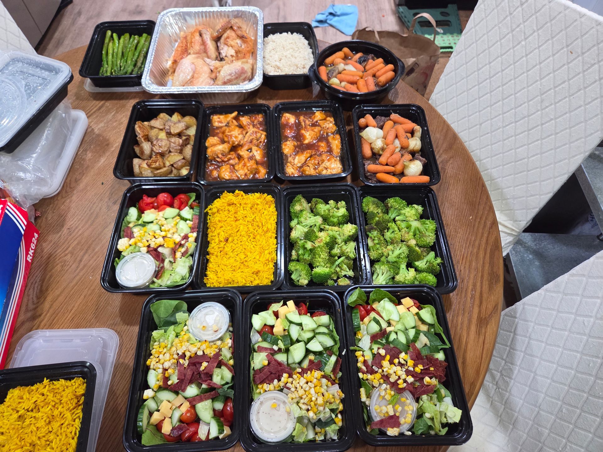 Meal prep with various dishes in black containers and a large baking pan.