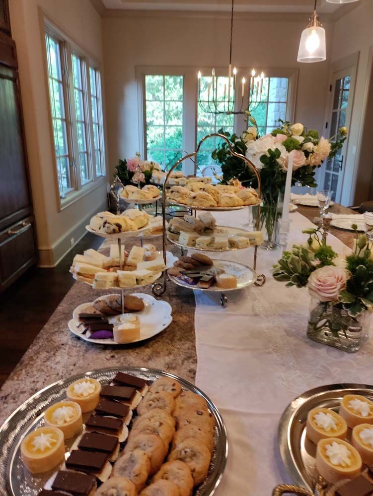 A table topped with plates of food and flowers.