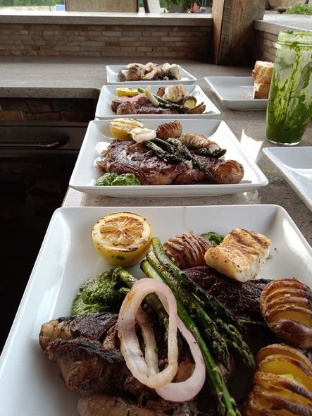 A row of plates of food are sitting on a table.