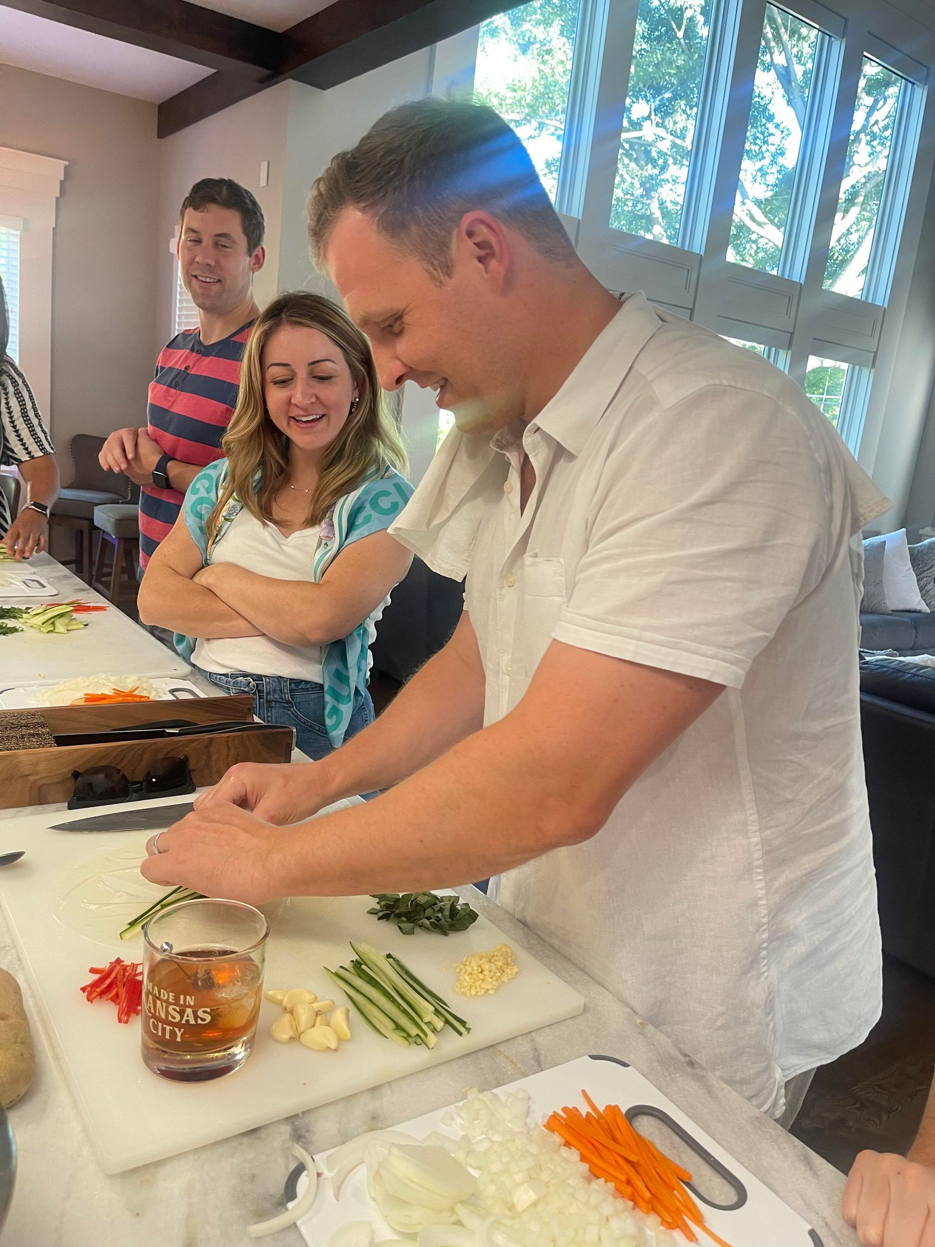 A person is pouring salt into a bowl of vegetables.