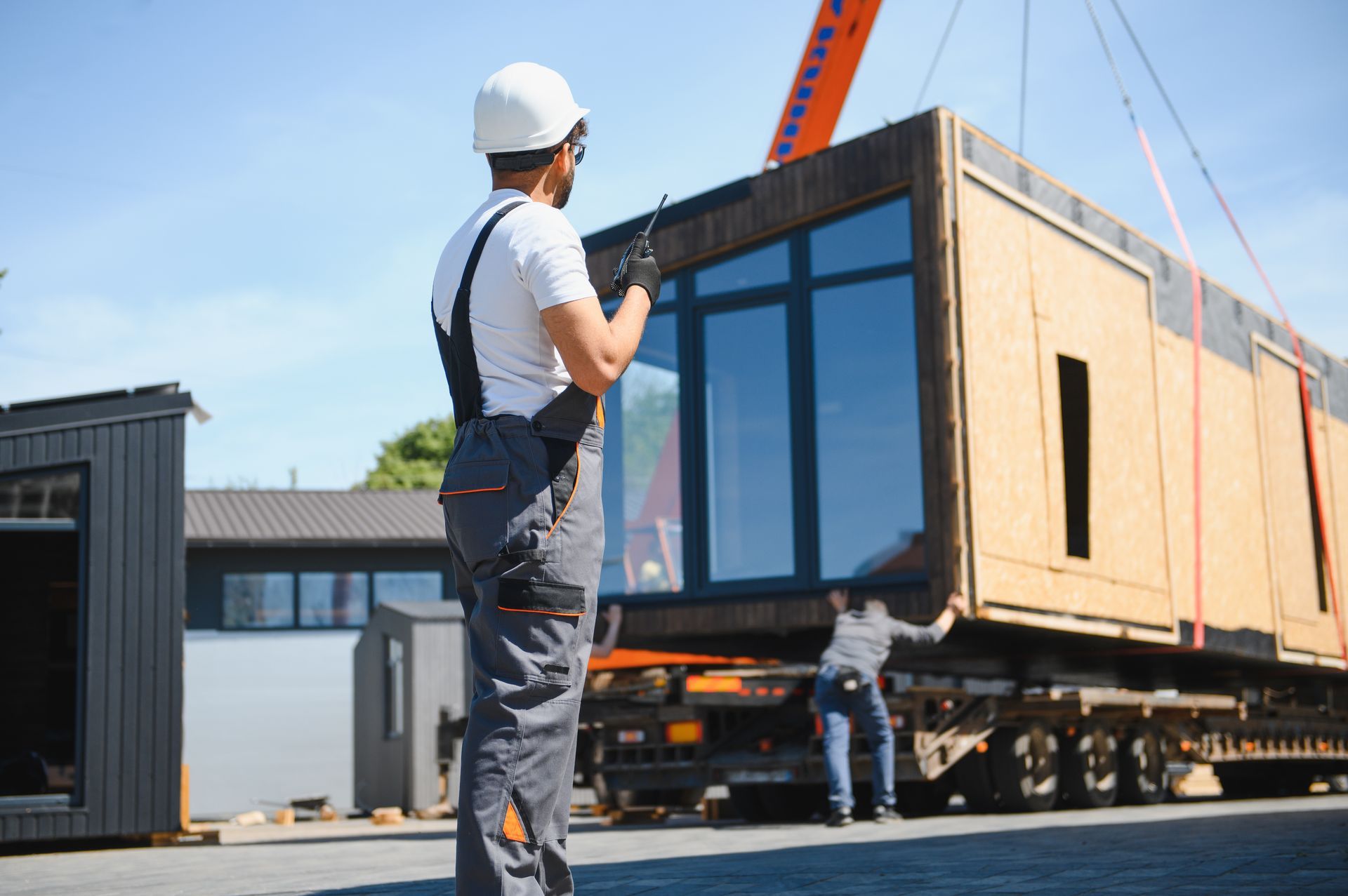 A house relocator supervising the loading of a modular house onto a truck. A house relocator supervising the loading of a modular house onto a truck.