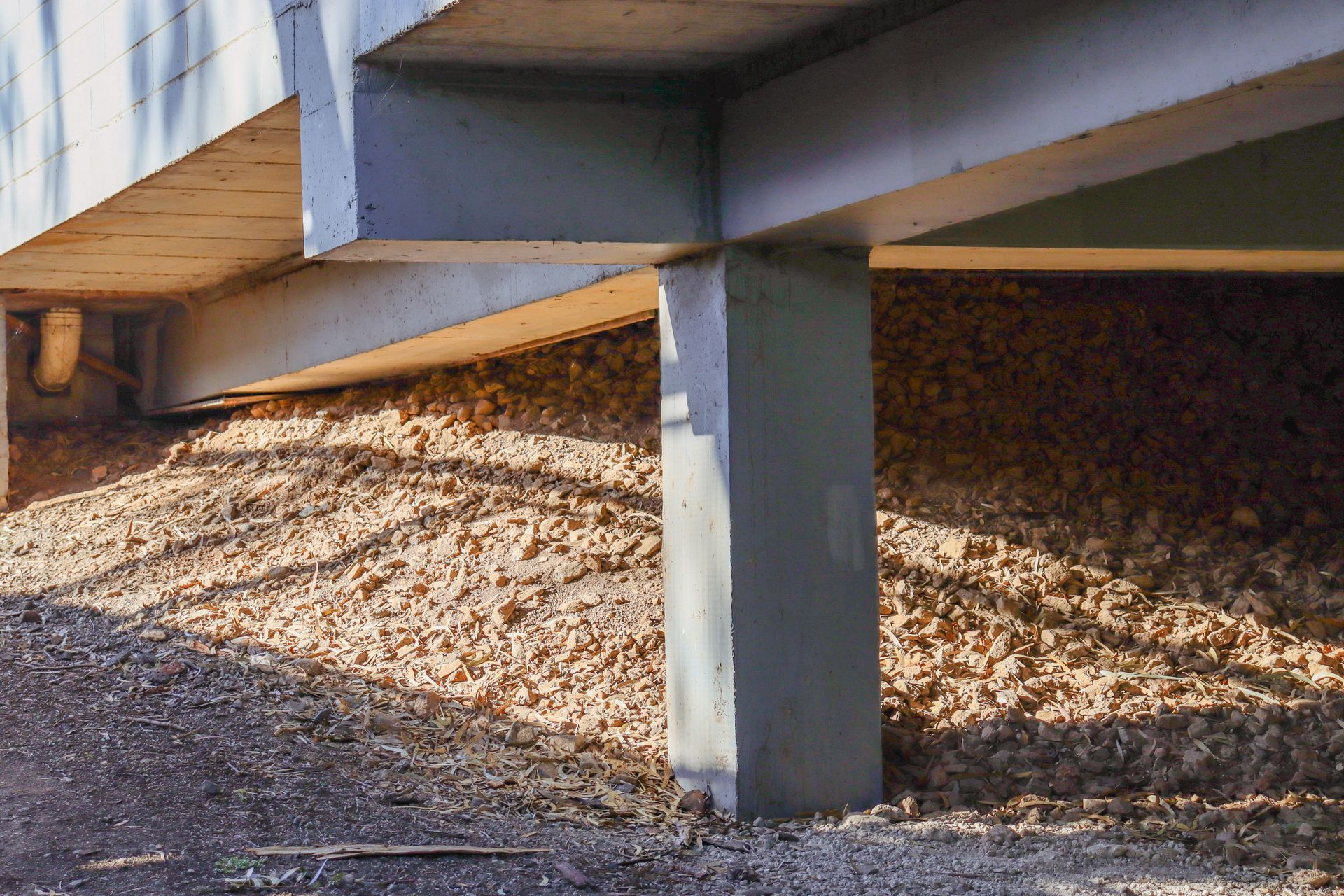 A close-up of a concrete restumping foundation under a building. A close-up of a concrete restumping foundation under a building.