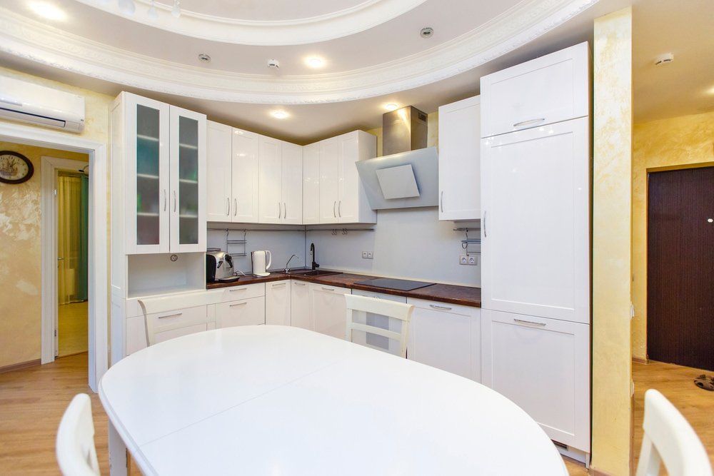 White Modern Kitchen With Elegant Ceiling And Lighting — Kitchen Design Experts in Central Coast, NSW