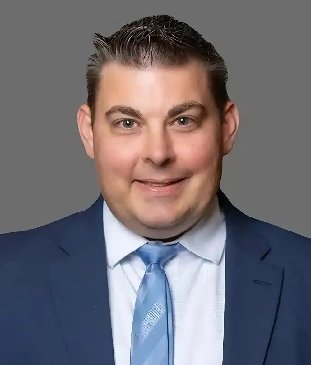 A man in a suit and tie is smiling for the camera.