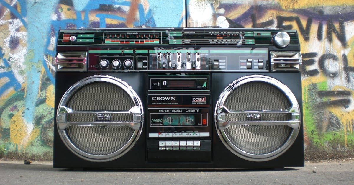 A boombox is sitting in front of a wall with graffiti on it