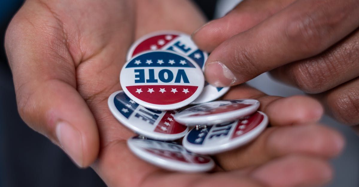 A person is holding a pile of vote buttons in their hands.