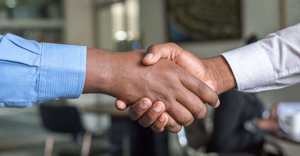 Two men are shaking hands in an office.