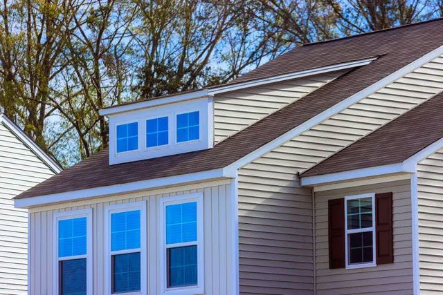 View of the Top Section of a Nice Light Yellow New House With Perfect Siding and Windows View of the Top Section of a Nice Light Yellow New House With Perfect Siding and Windows