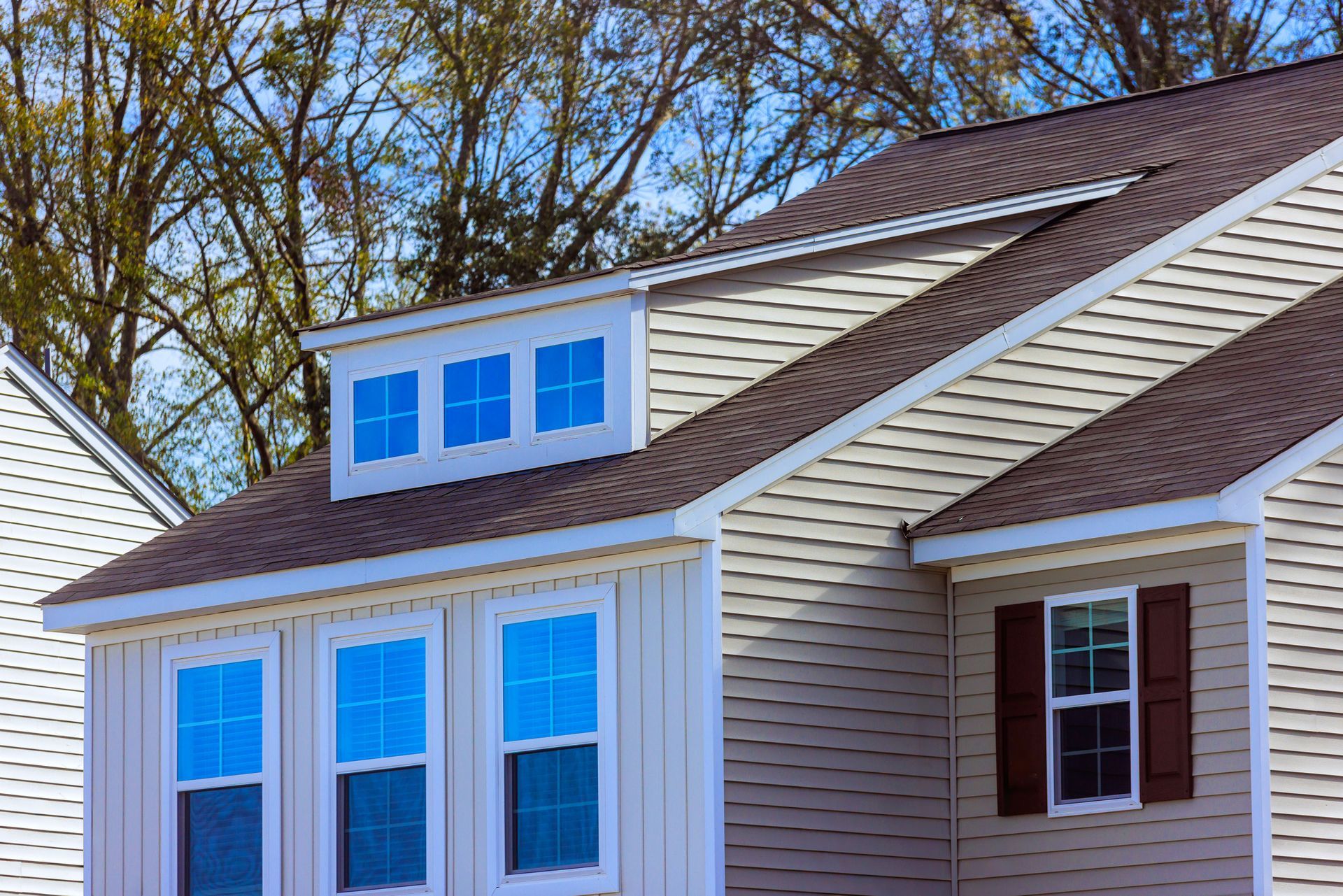 View of the Top Section of a Nice Light Yellow New House With Perfect Siding and Windows View of the Top Section of a Nice Light Yellow New House With Perfect Siding and Windows
