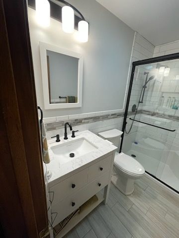 A bathroom with a sink , toilet , mirror and shower | Champaign, IL | Unity Construction
