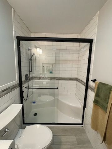 A bathroom with a toilet , sink , shower and bathtub | Champaign, IL | Unity Construction