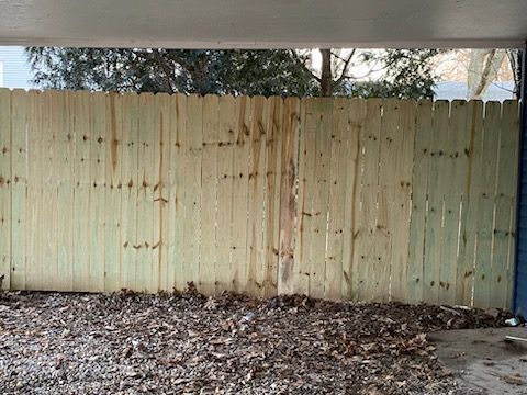 A wooden fence is surrounded by leaves in a parking lot | Champaign, IL | Unity Construction