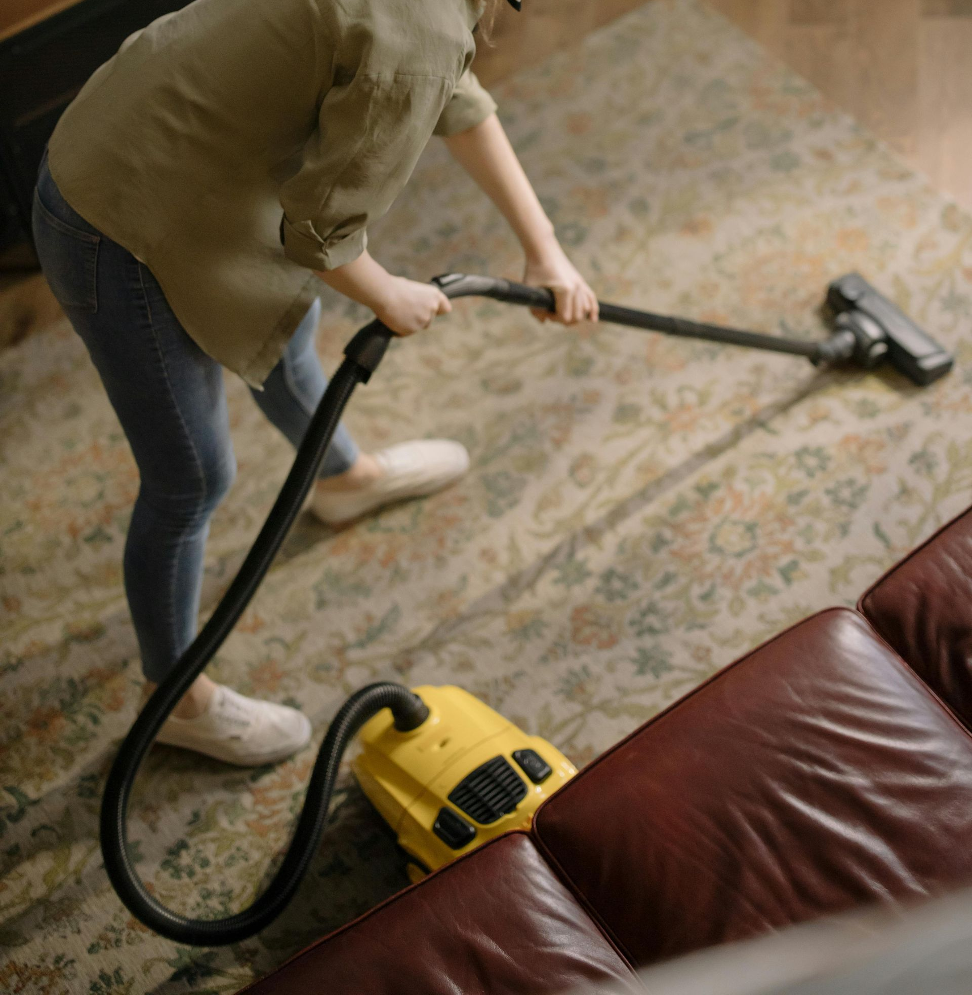 A man is cleaning a wooden deck with a high pressure washer.