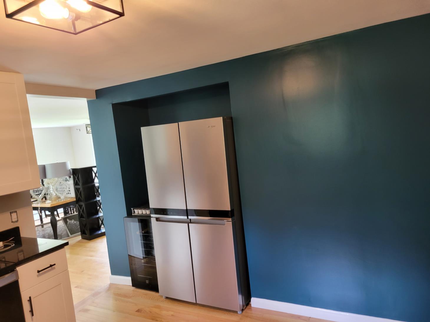 A kitchen with blue walls and a stainless steel refrigerator.