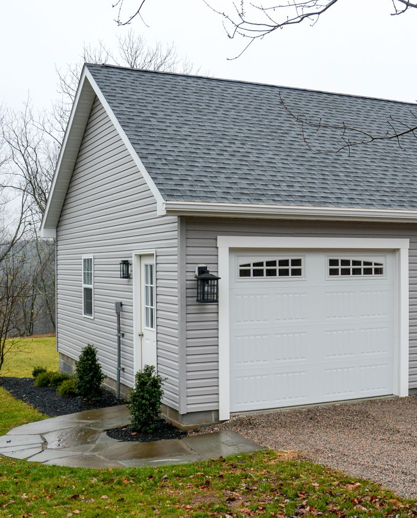 gray shed An Amish-built garage with a copper cupola on top of it