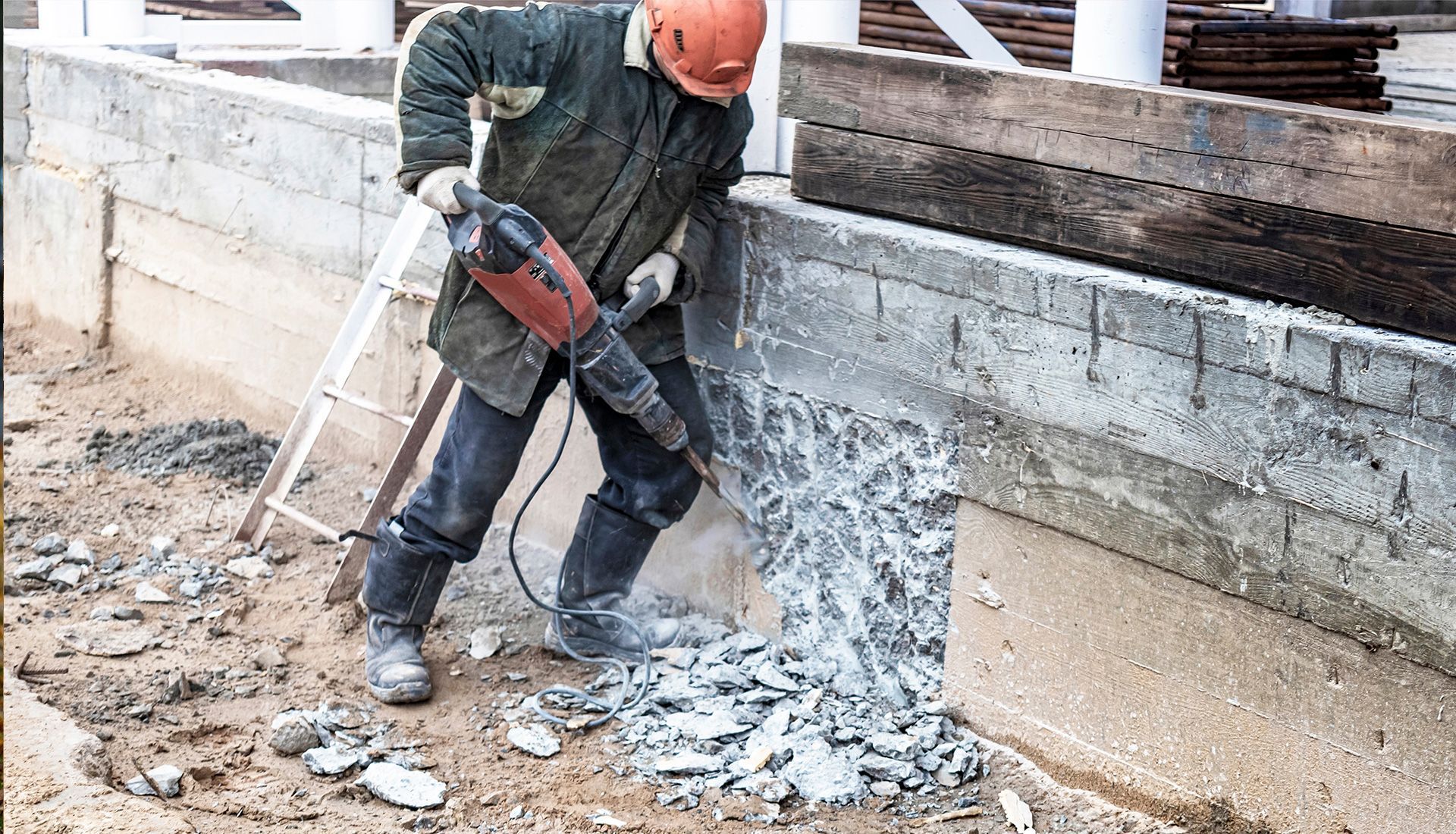 Yellow and black excavator demolishing debris on a construction site.