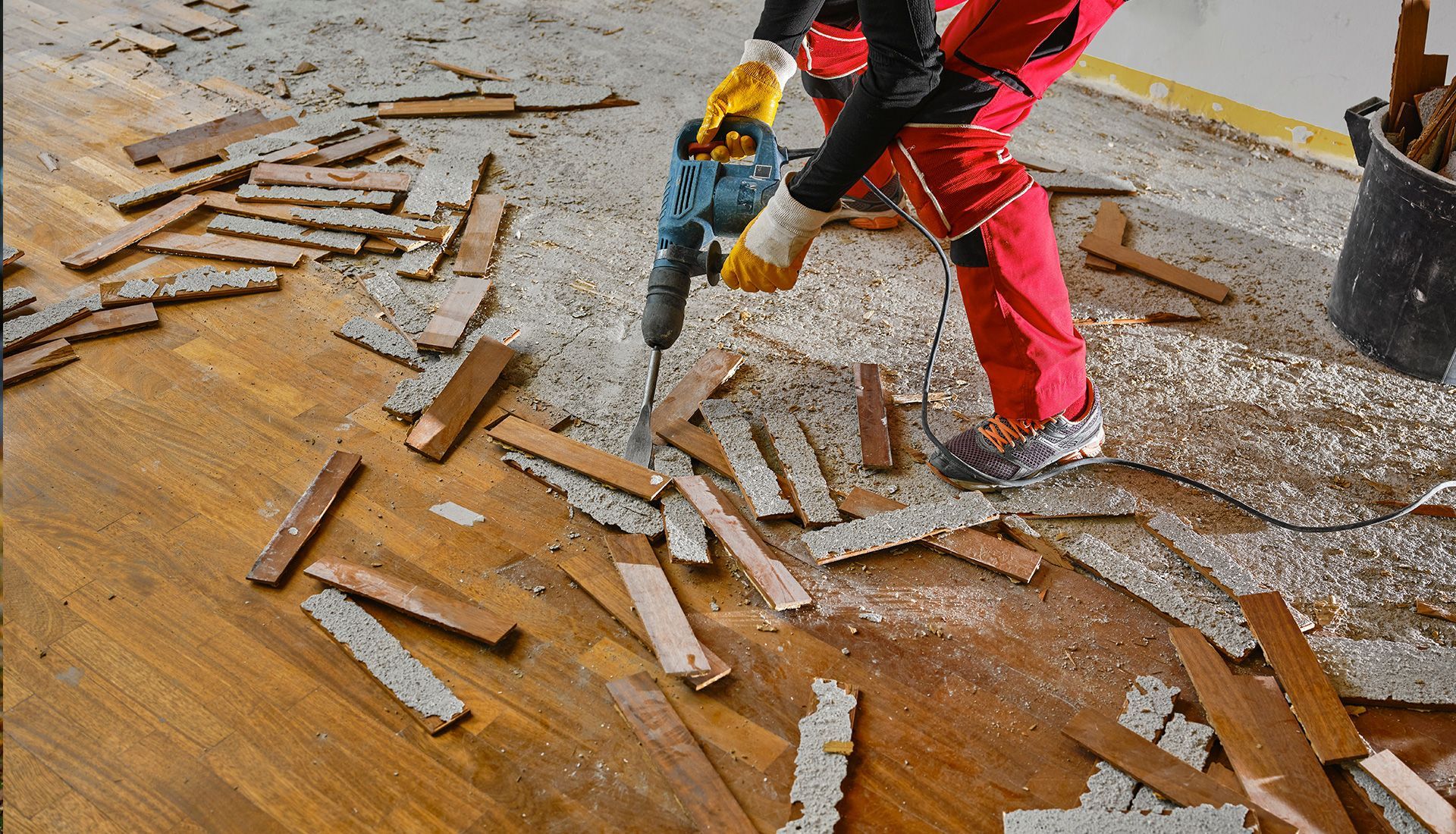 Two sanitation workers loading yellow recycling bin onto green garbage truck.