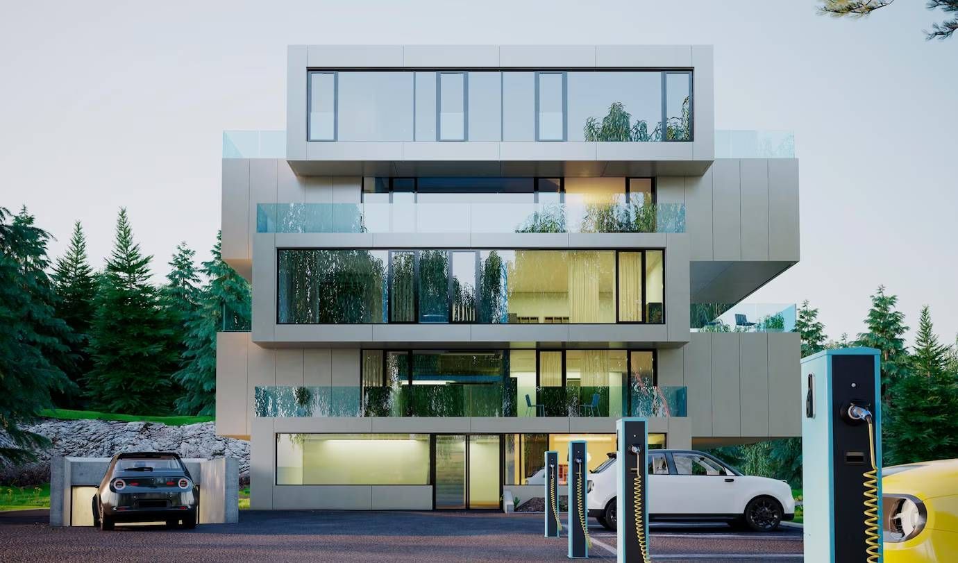 Modern building with balconies, reflective windows, and EV charging stations in front.