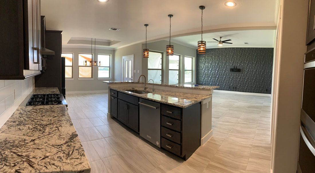 Modern kitchen with island, dark cabinets, granite counters, tile floors, and pendant lights.