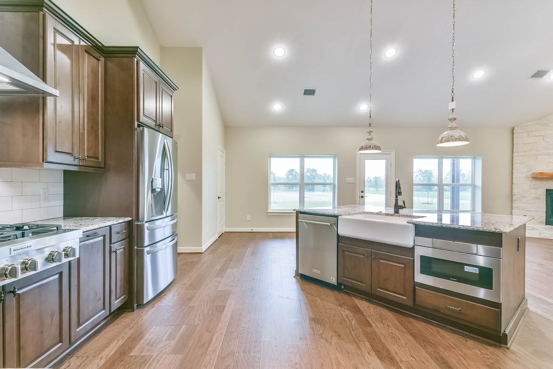 Kitchen with dark wood cabinets, stainless steel appliances, and island.