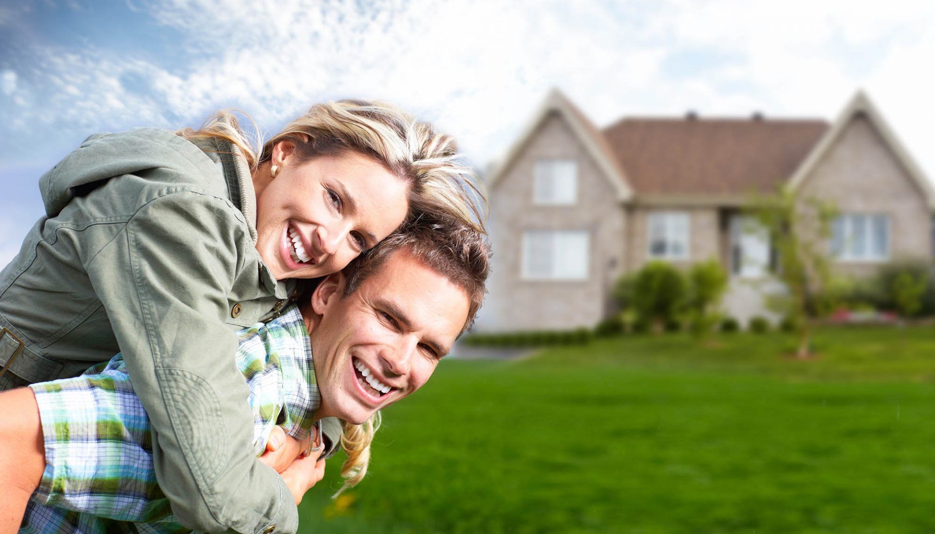 happy couple with house and green lawn on background