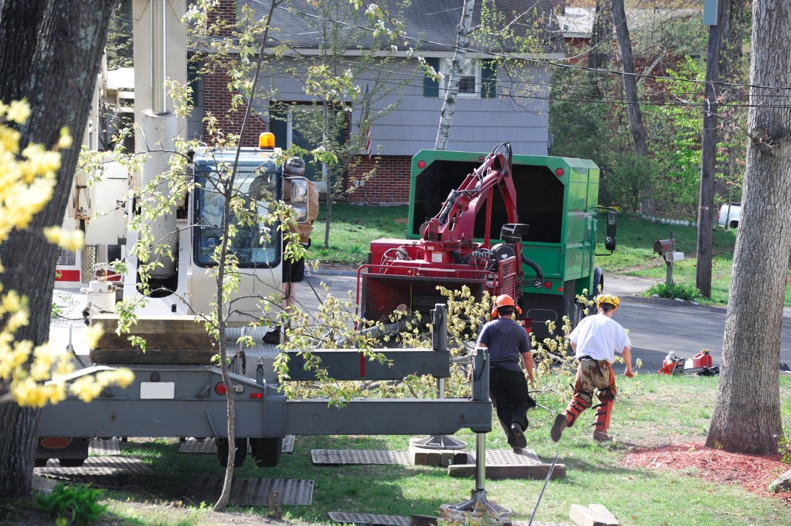 A green truck is parked in front of a house