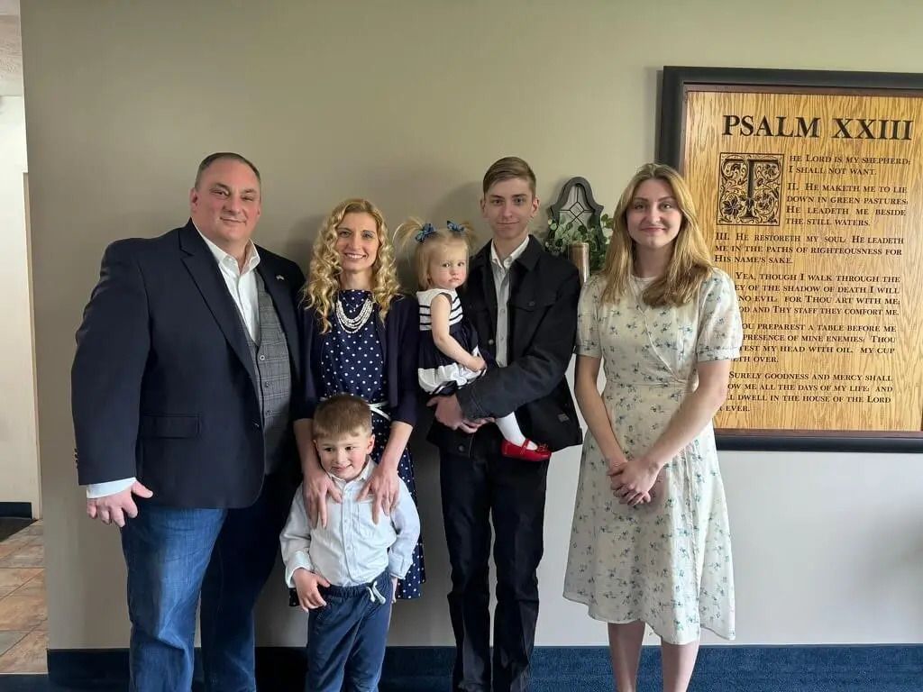 Family posing together near Psalm XXIII plaque.