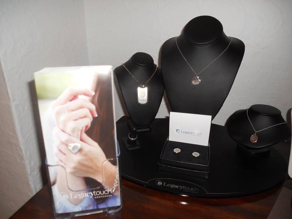 Jewelry display on black stands, including necklaces, earrings, and an advertisement on a tabletop.