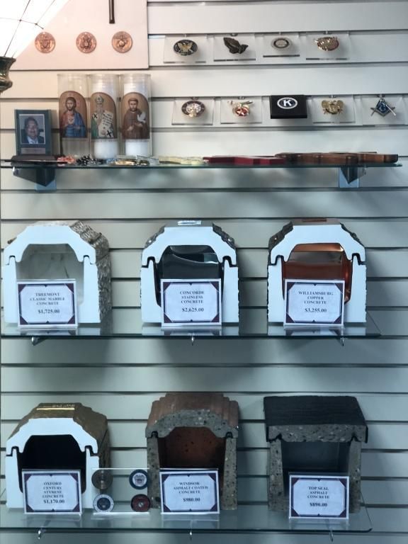 Display case with urns, candles, and medals; various colors and materials.