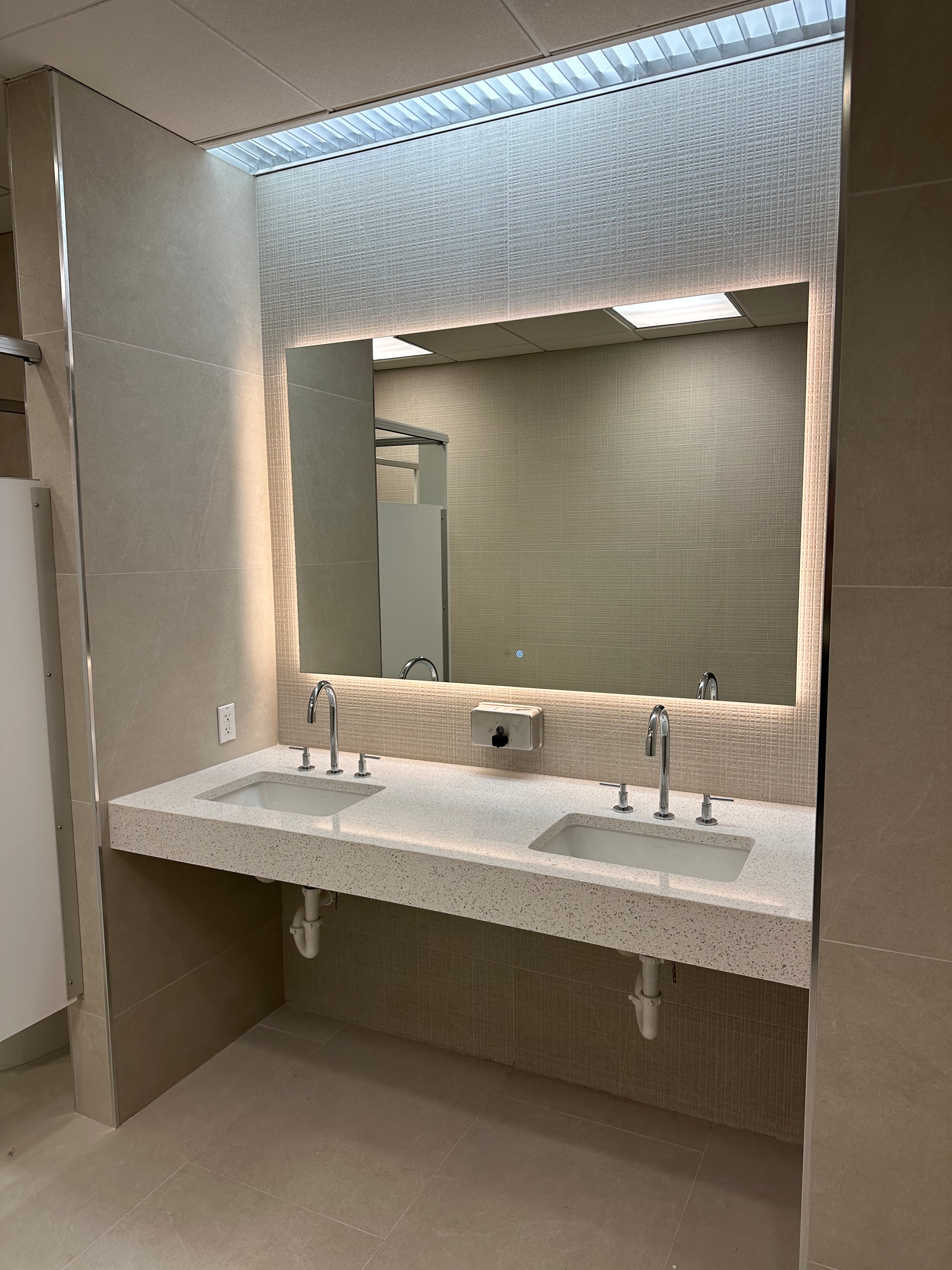A bathroom with two sinks and a large mirror.