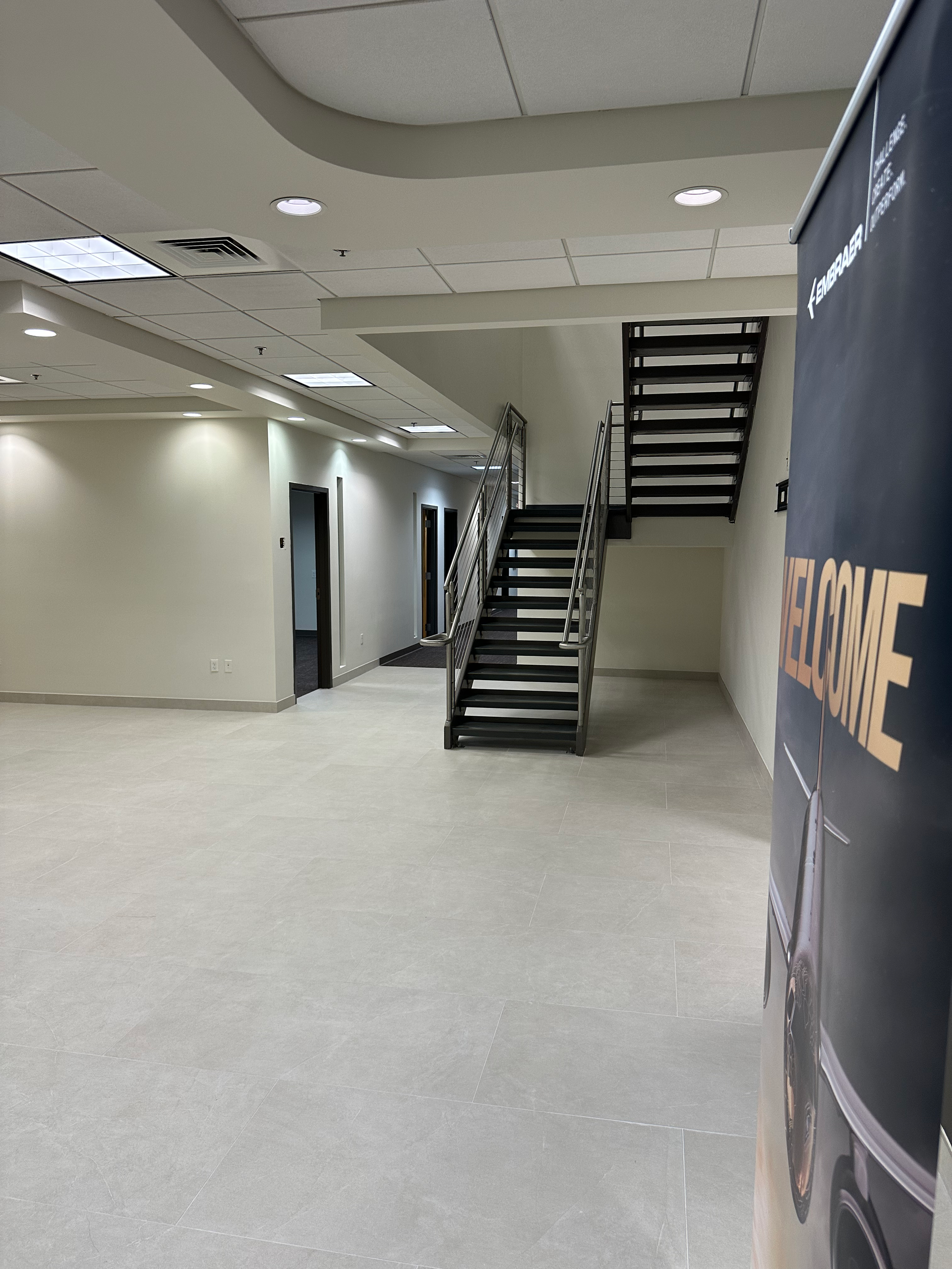 An empty room with stairs and a sign that says welcome