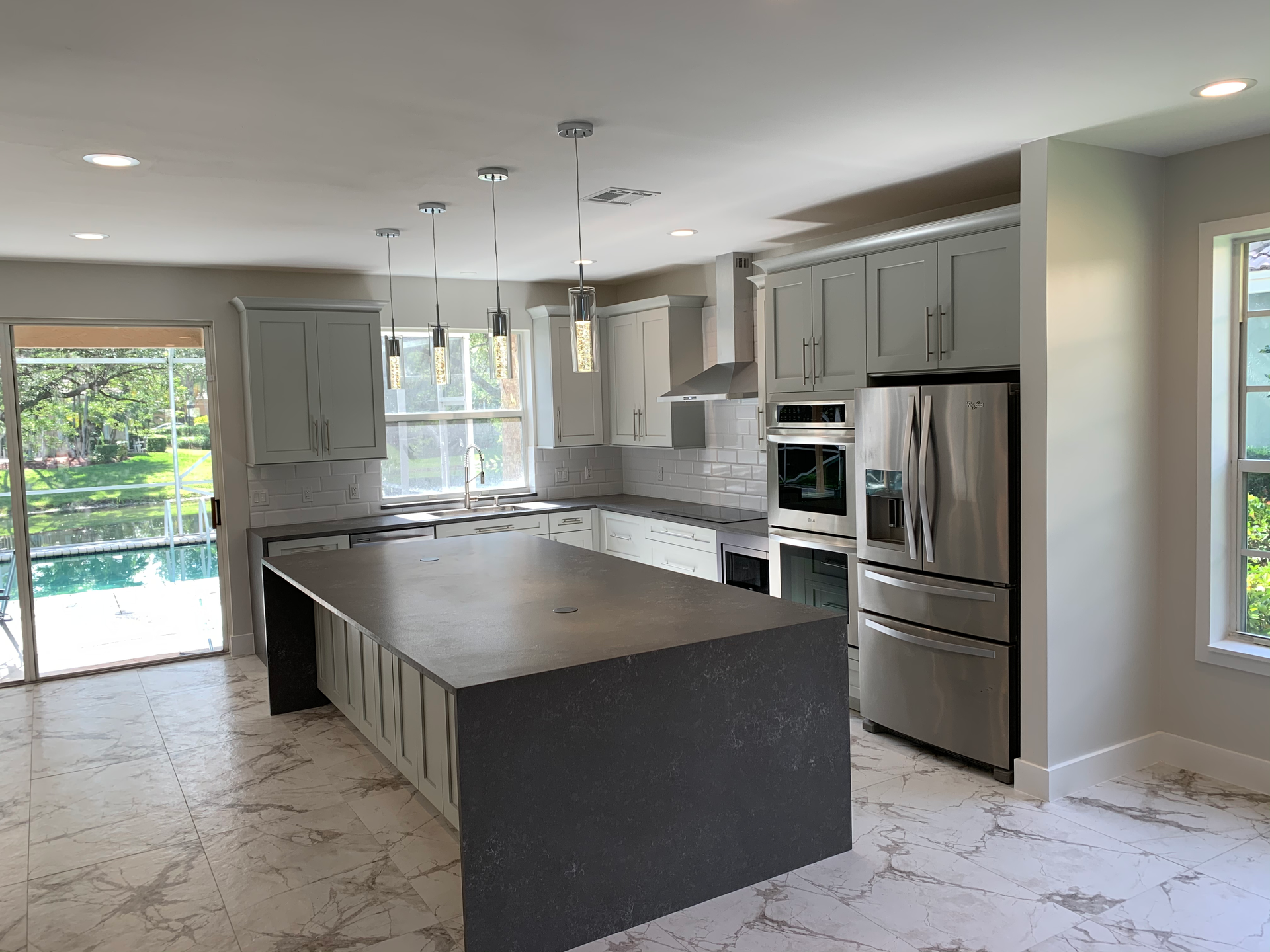 A kitchen with a large island and stainless steel appliances.
