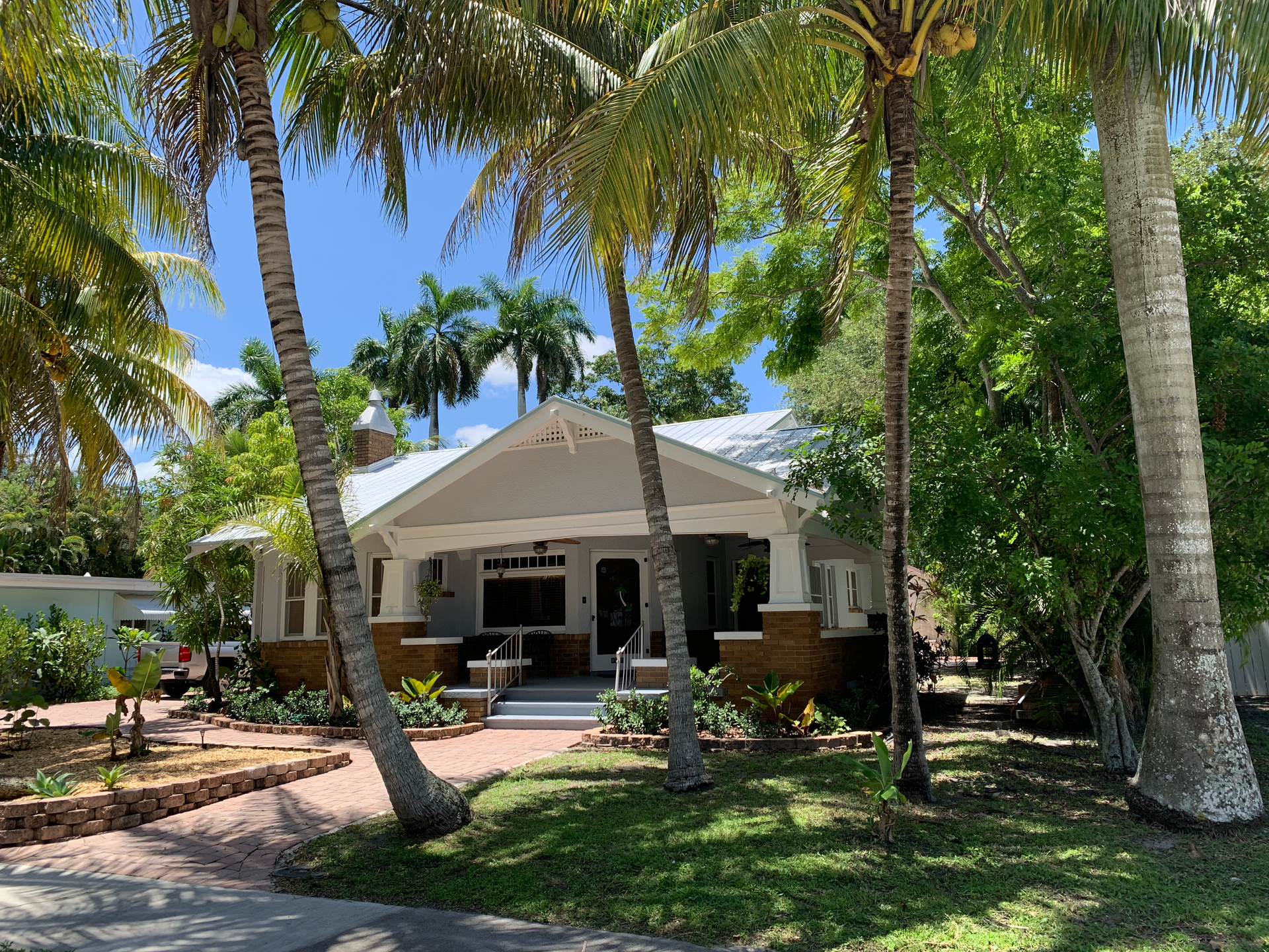 A house surrounded by palm trees on a sunny day