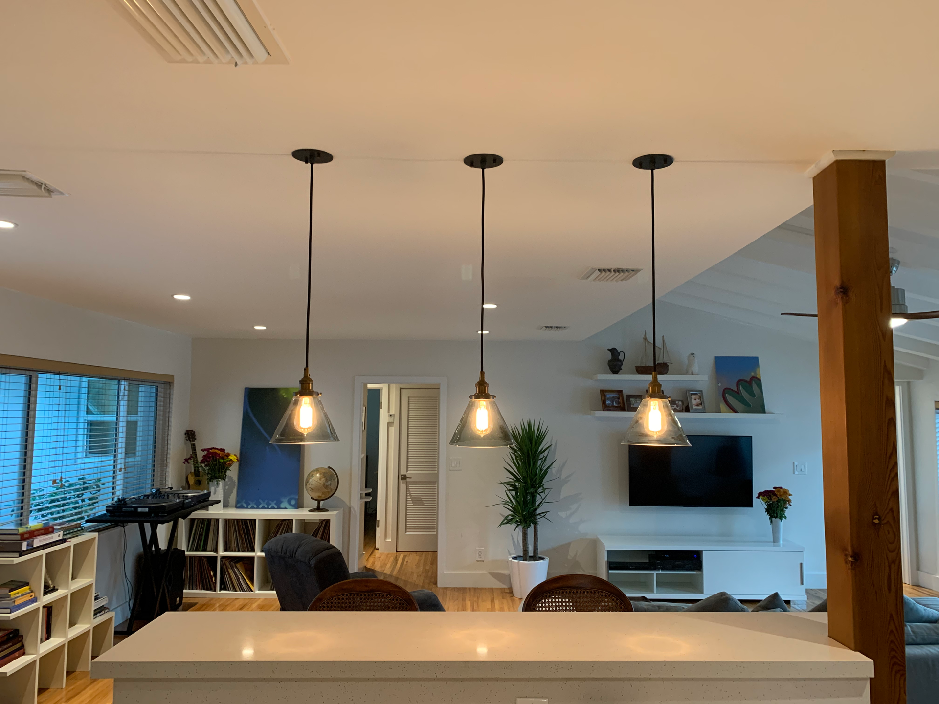 A living room with a kitchen and a television.