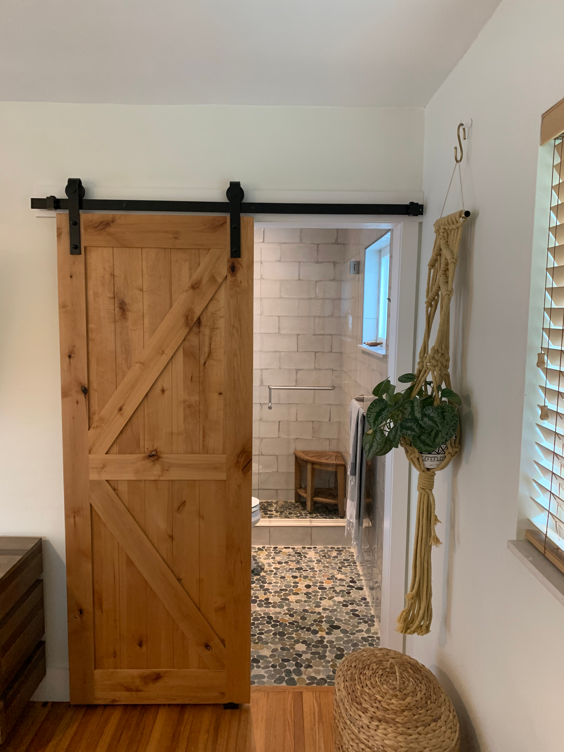 A bedroom with a sliding barn door leading to a bathroom.