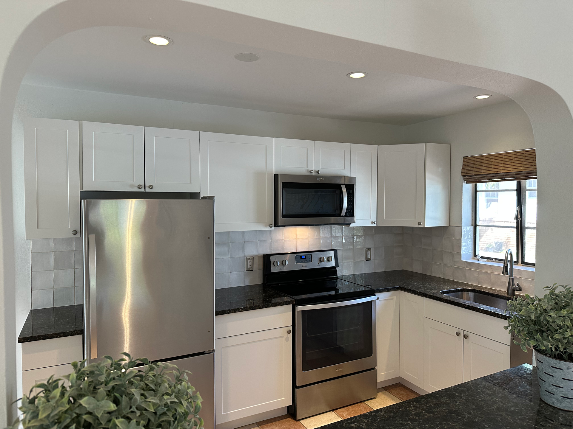 A kitchen with stainless steel appliances and white cabinets