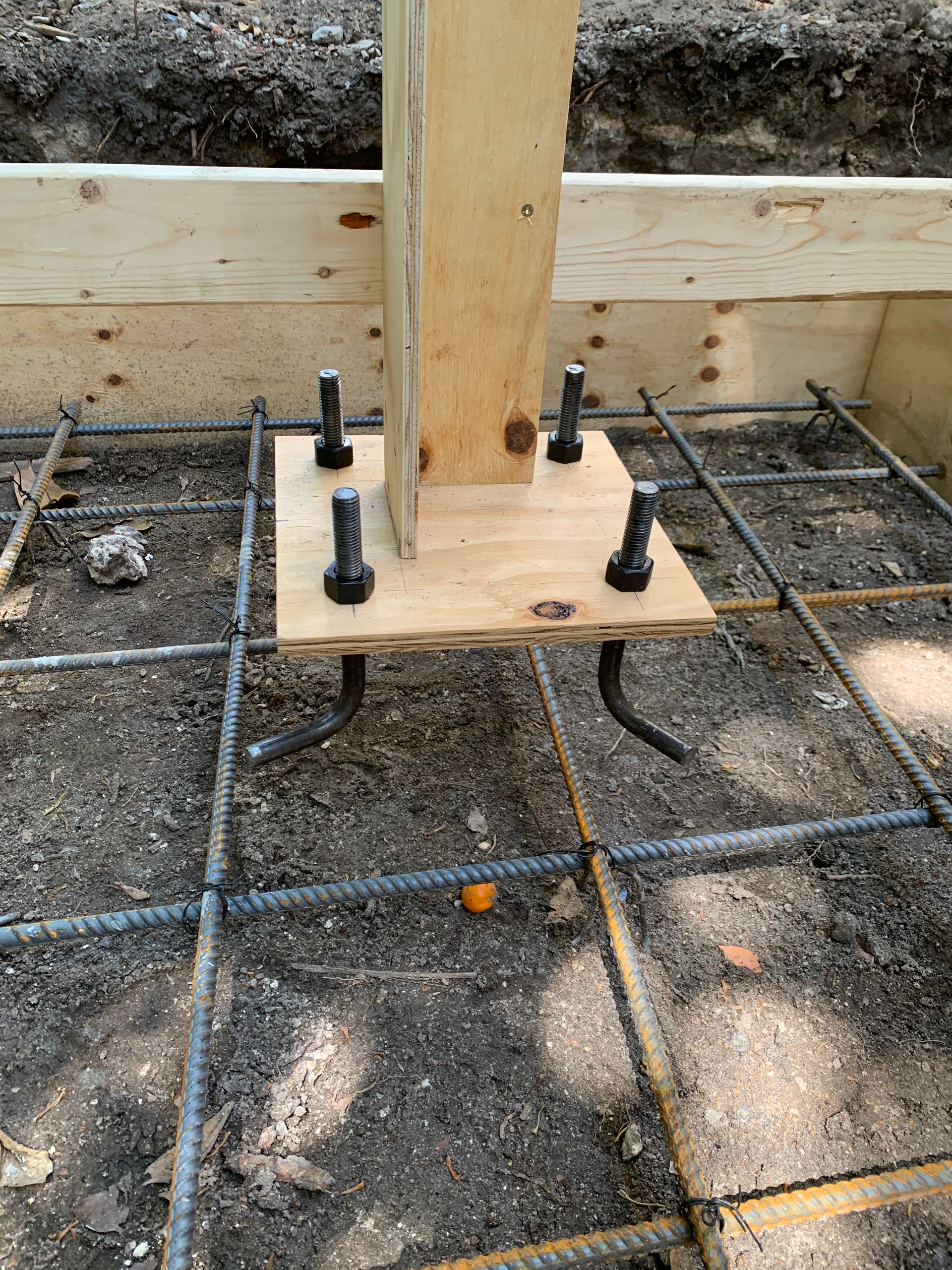 A wooden post is sitting on top of a concrete base.