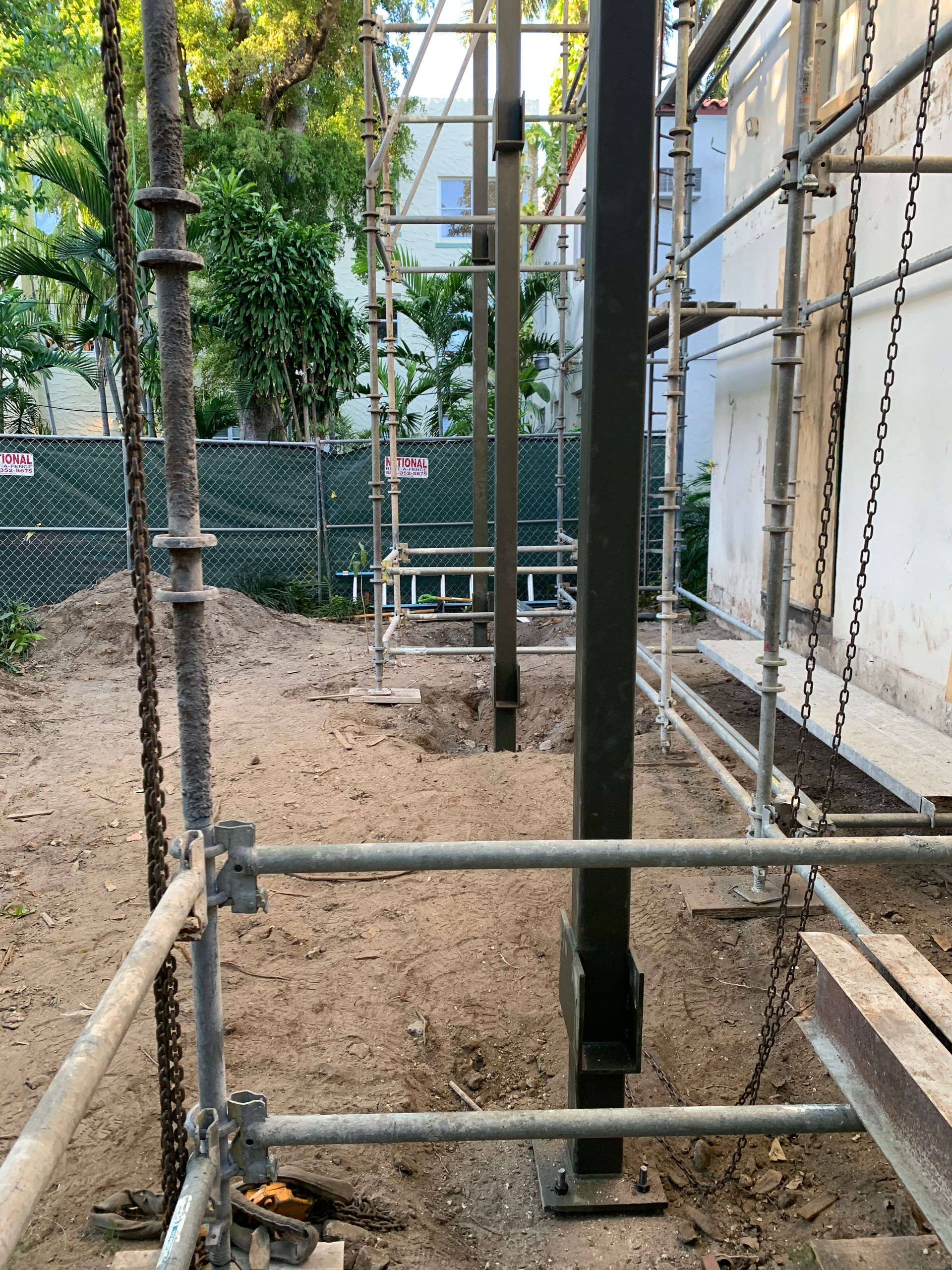 A fenced in area with scaffolding and chains around it