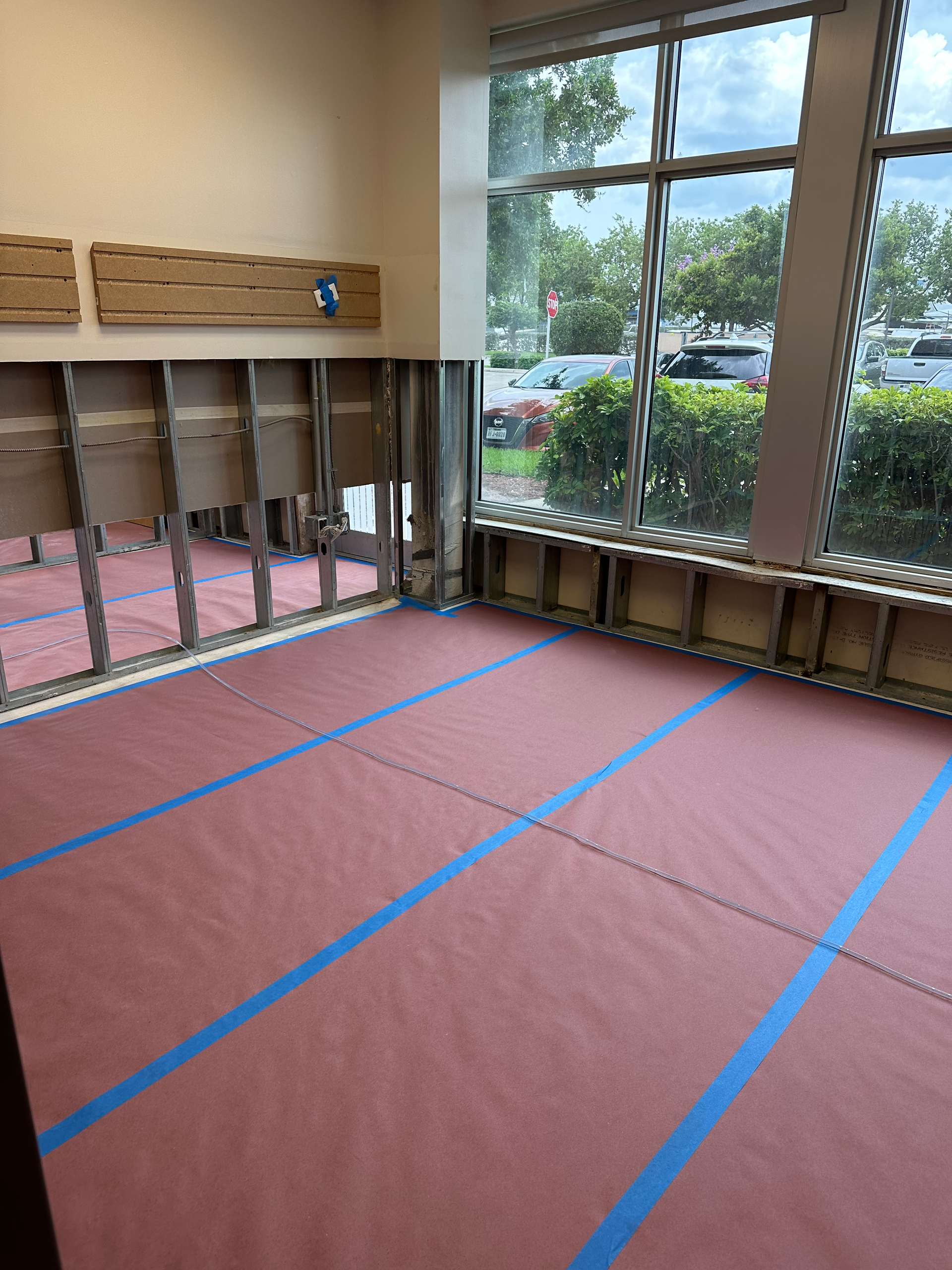A room with a pink floor and blue tape on the floor.