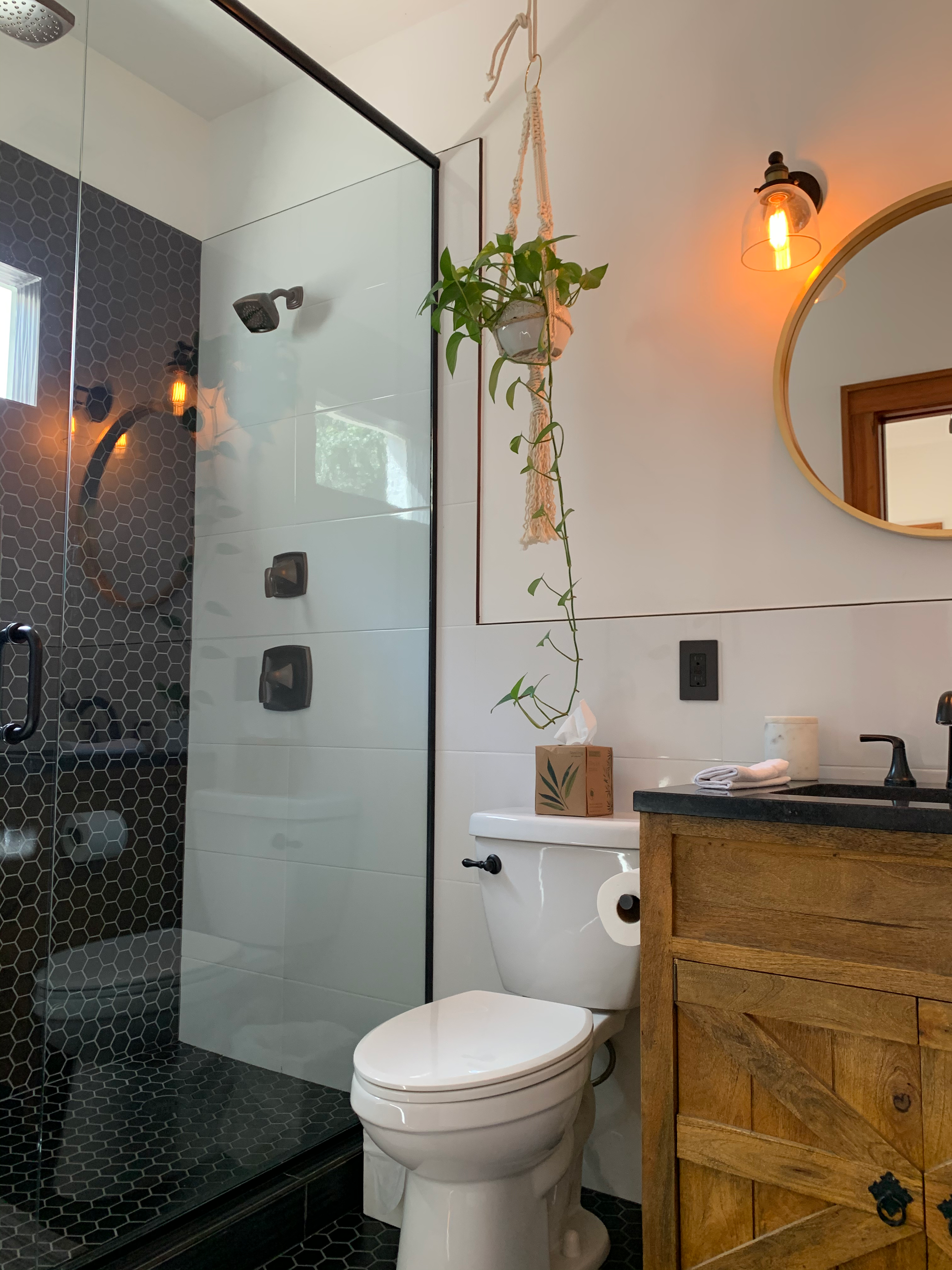 A bathroom with a toilet , sink , mirror and shower.