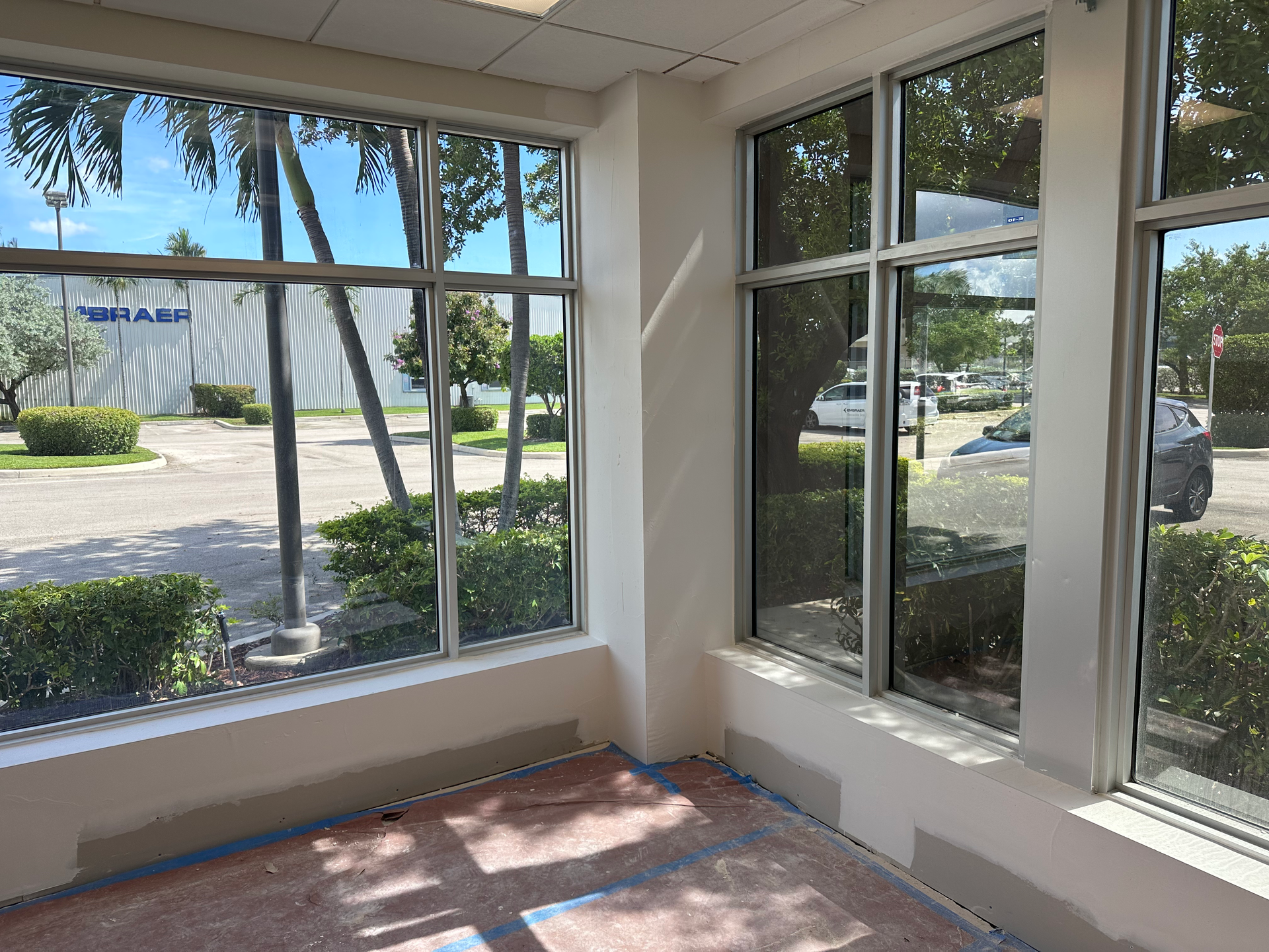 A room with a lot of windows and a building in the background.