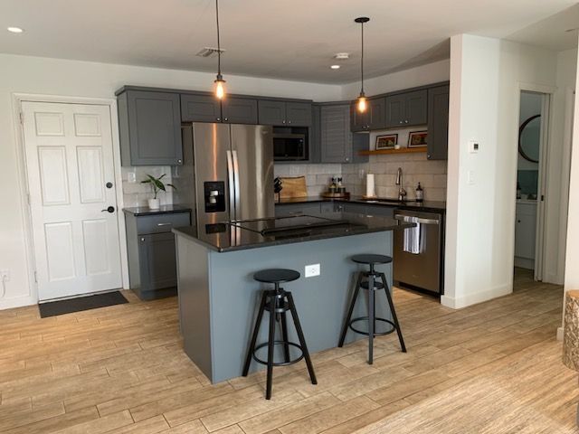 A kitchen with a large island and two stools