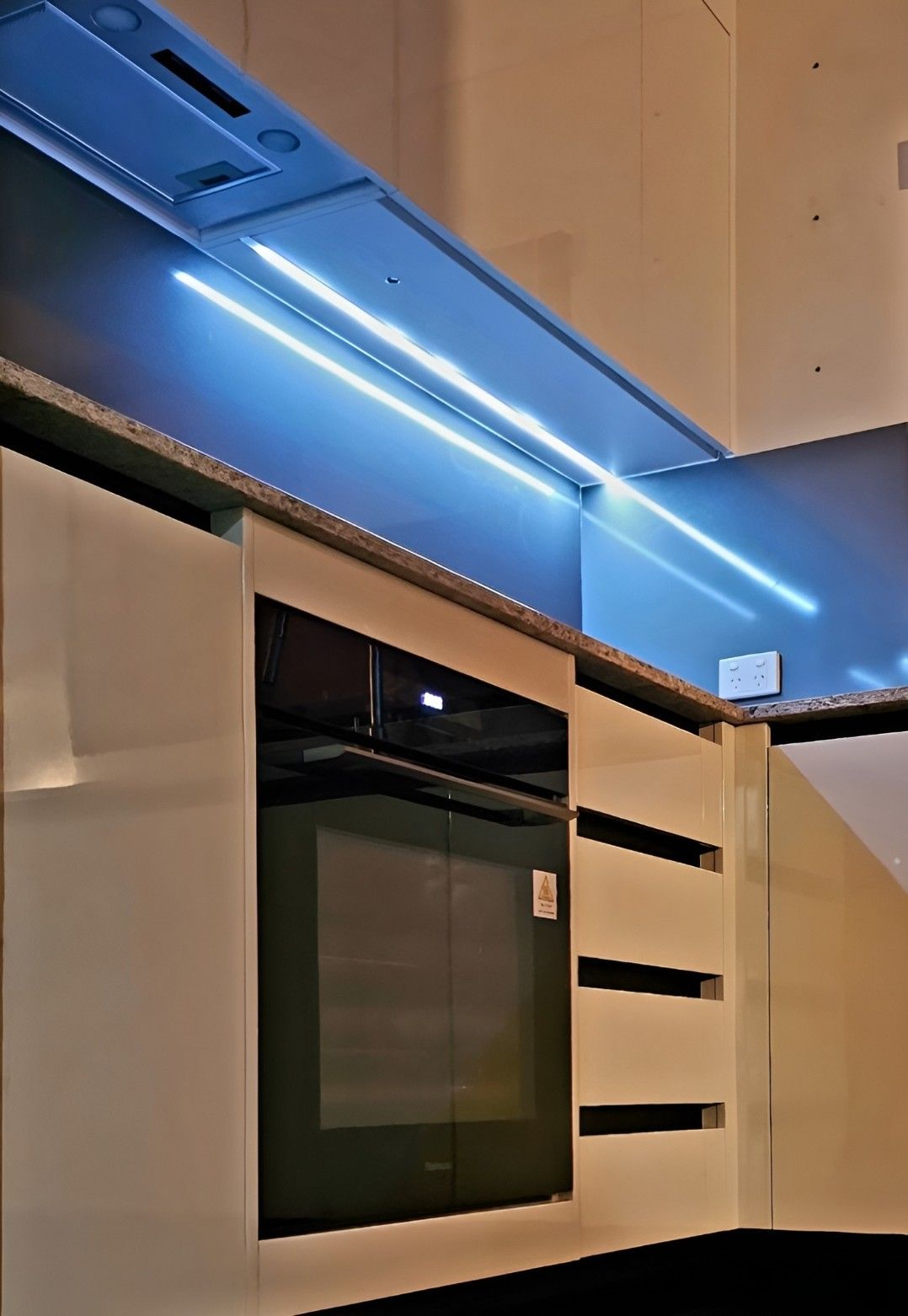 A Kitchen With a Black Oven and White Cabinets — Mackay Cabinetmaking Service In Glenella, QLD