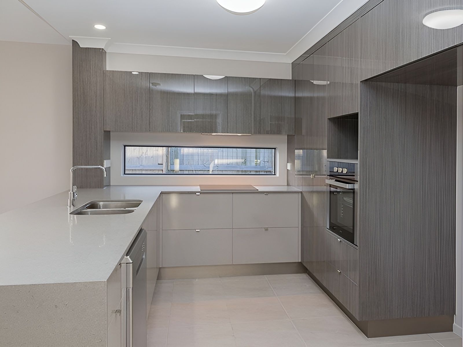 A Kitchen With Gray Cabinets and White Counter Tops — Mackay Cabinetmaking Service In Glenella, QLD