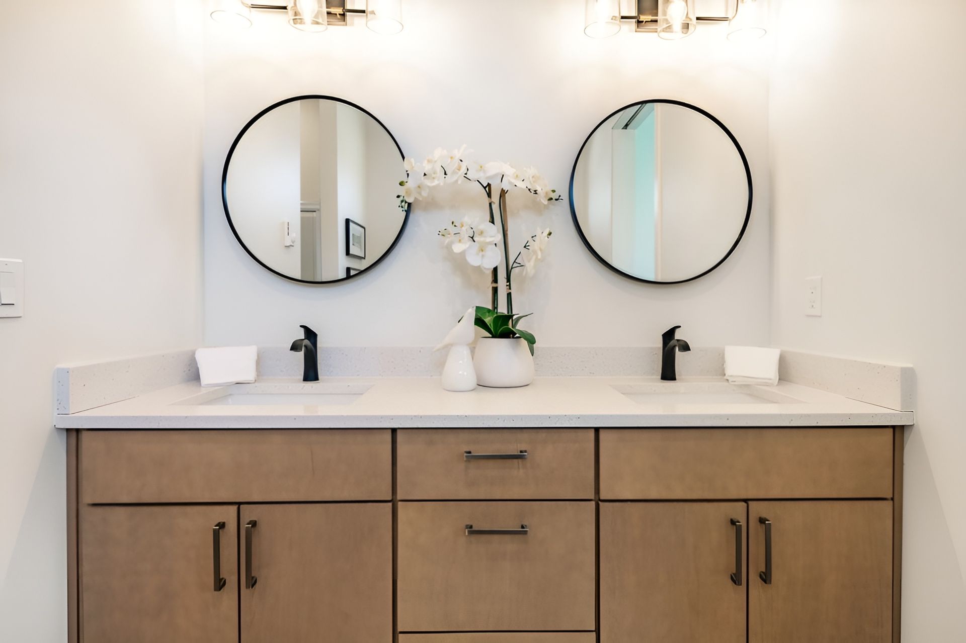 A Bathroom With Two Sinks and Two Round Mirrors — Mackay Cabinetmaking Service In Glenella, QLD