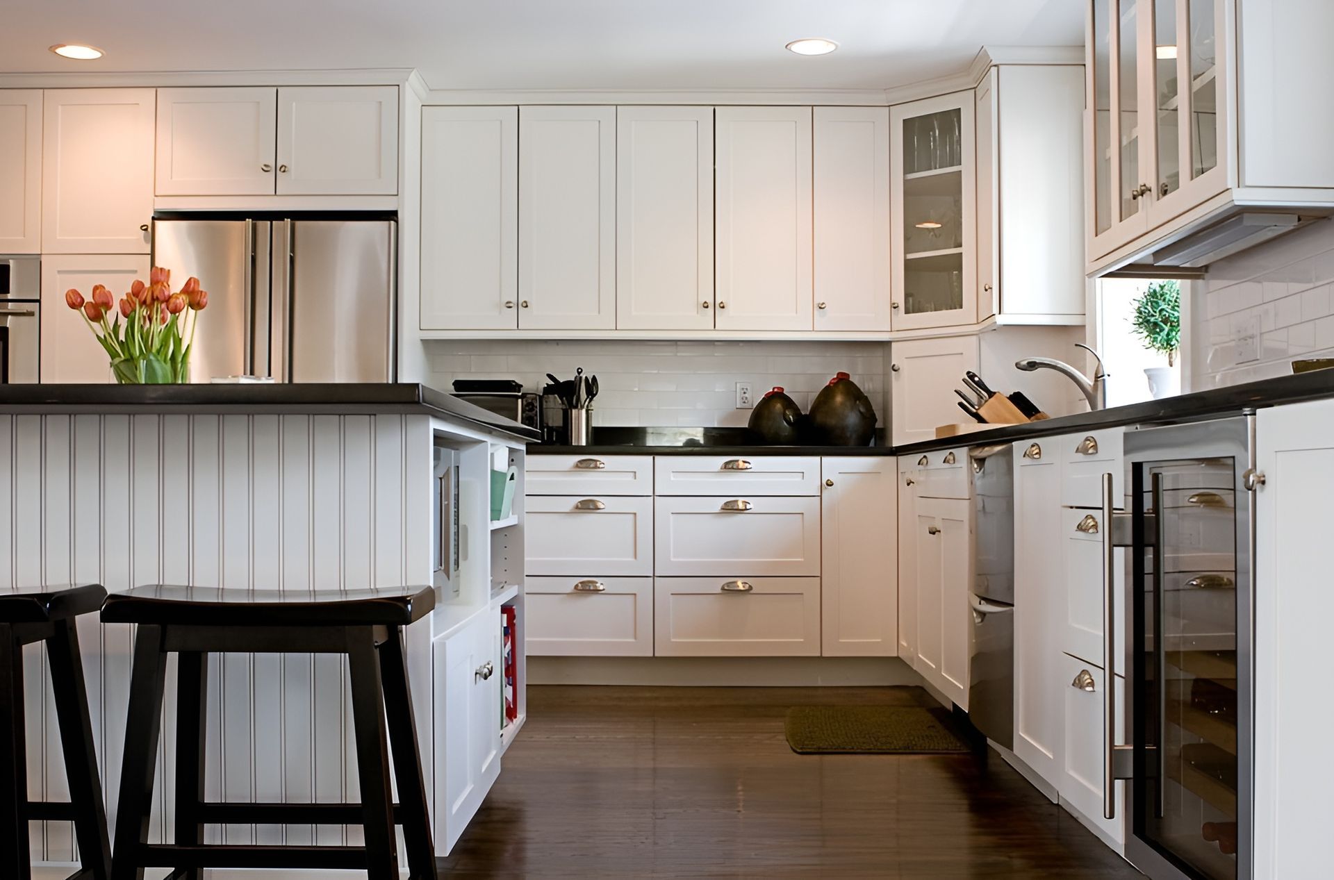 A Kitchen With White Cabinets and Black Counter Tops — Mackay Cabinetmaking Service In Glenella, QLD