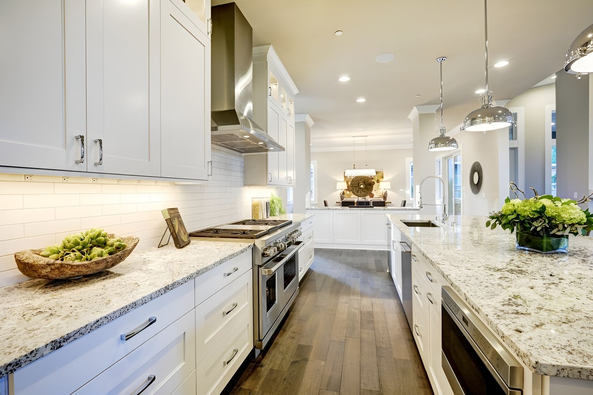 A Kitchen With White Cabinets, Granite Counter Tops  — Mackay Cabinetmaking Service In Glenella, QLD